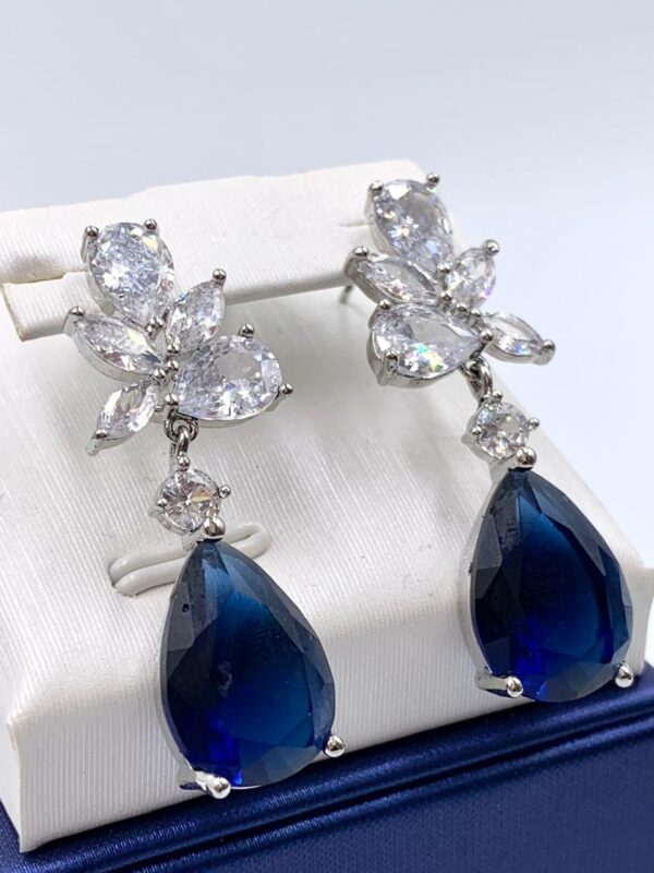 Aretes con piedra azul y detalles blancos